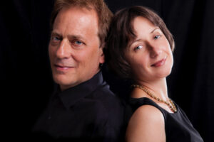 Portrait of violinist Solomia Soroka and pianist Arthur Greenewith a dark background